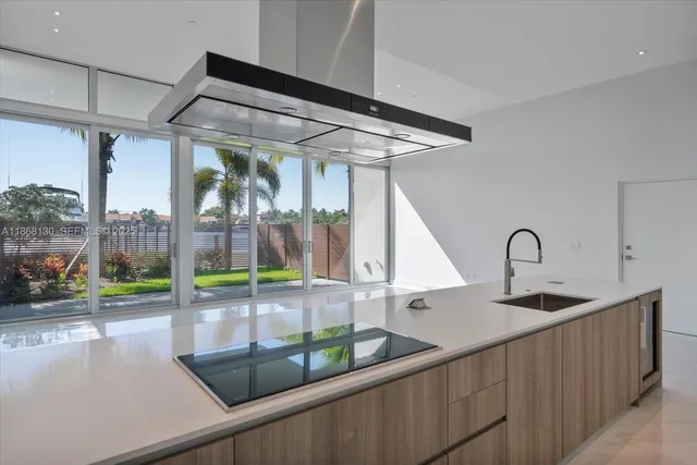 a kitchen with kitchen island a large window in it