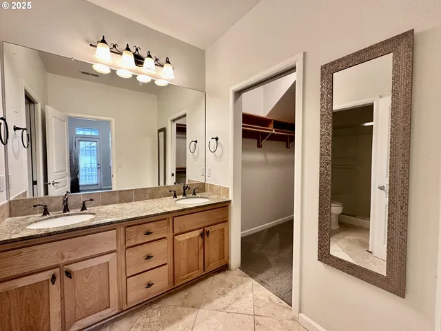 a spacious en suite bathroom with a granite countertop sink mirror and shower