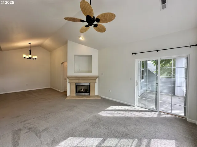 a view of an empty room with a fireplace and a window