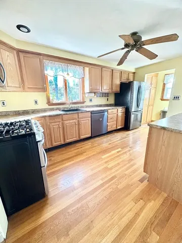 a open kitchen with stainless steel appliances granite countertop a stove and a wooden floors