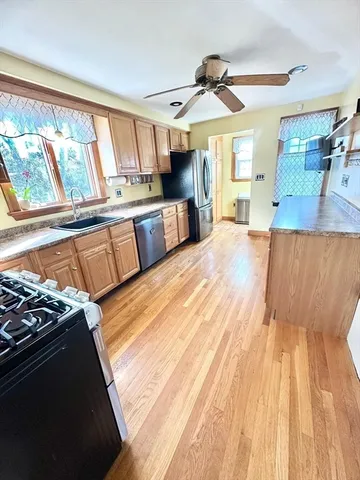 a open kitchen with stainless steel appliances granite countertop a stove and a wooden floors