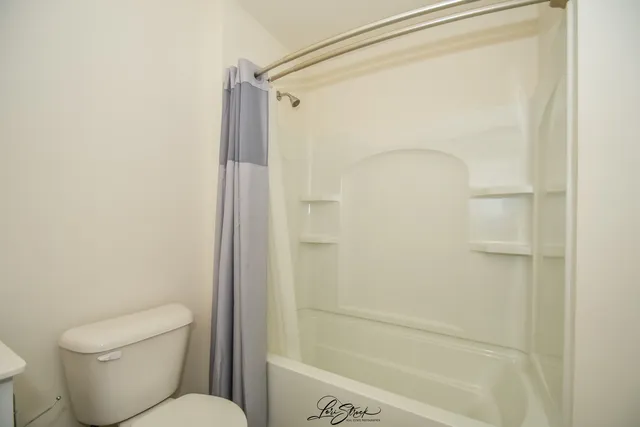 a bathroom with a shower and a toilet
