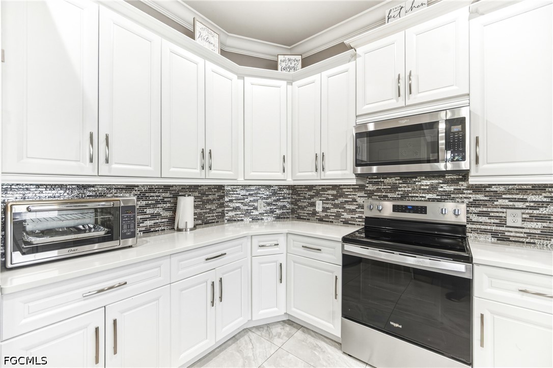 1700 43rd Terrace Southwest Naples, FL 34116 - Photo 9 of 38 a kitchen with white cabinets appliances and a sink