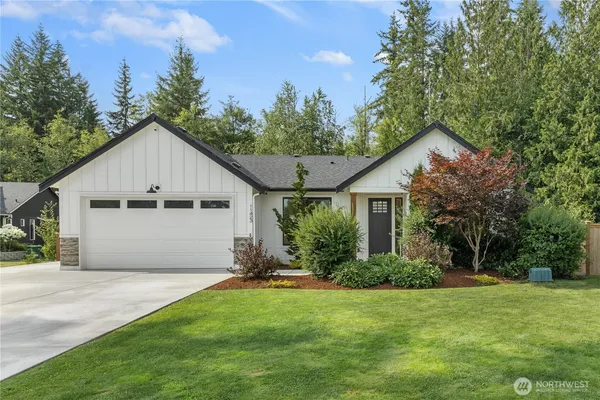 a front view of house with yard and trees in the background