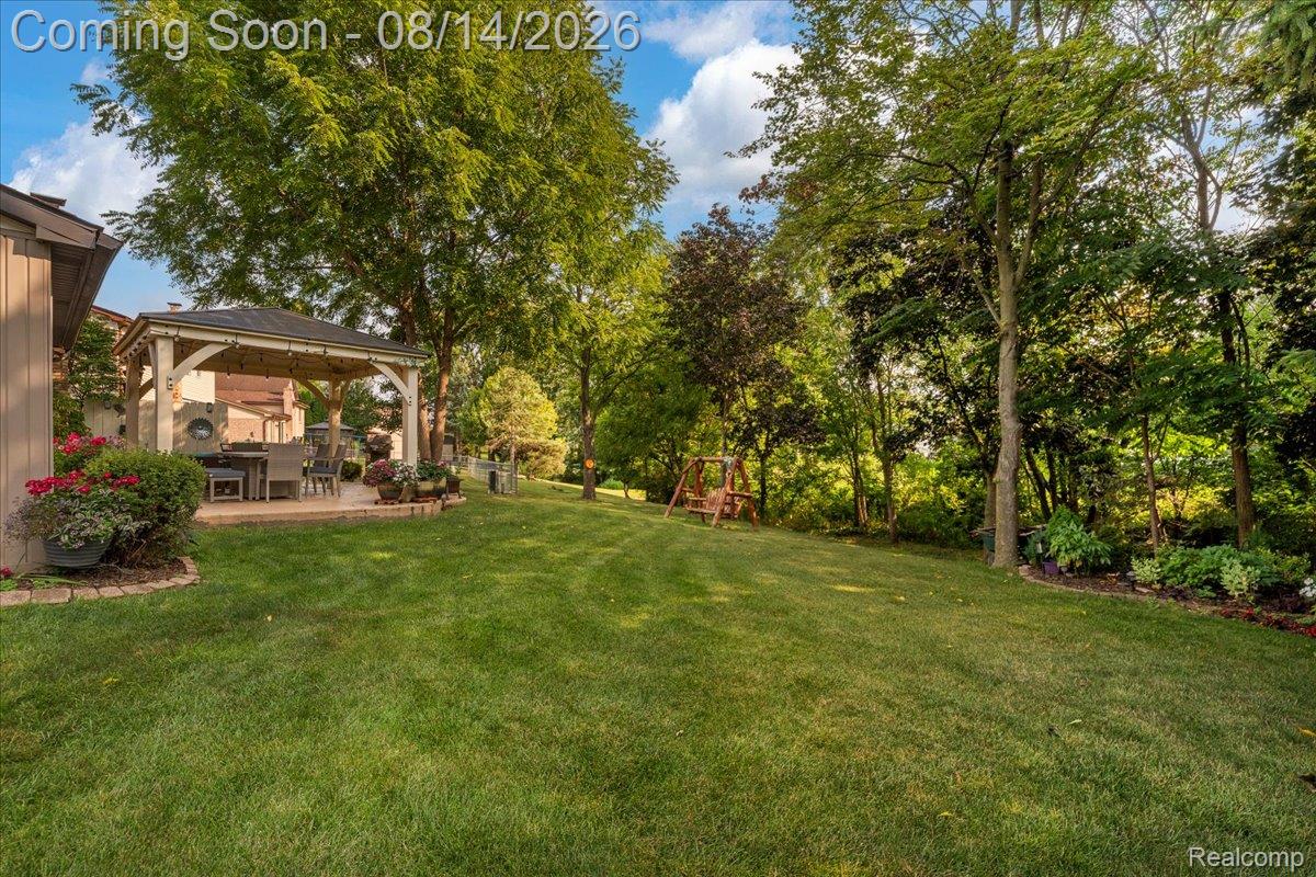 47321 Susan Road Macomb, MI 48044 - Photo 33 of 46 Expansive green lawn with mature trees and a dedicated patio featuring a built-in gazebo