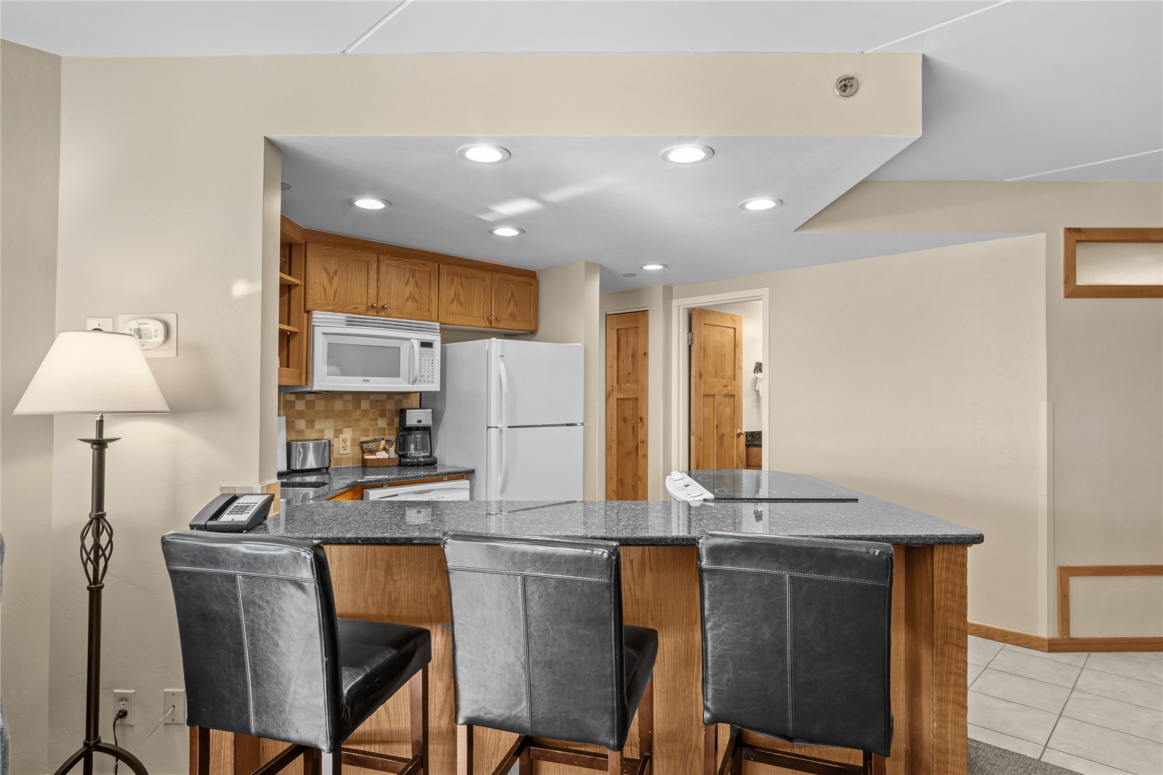 640 Village Road, Unit 4110 Breckenridge, CO 80424 - Photo 8 of 50 a kitchen with stainless steel appliances granite countertop a stove a refrigerator a kitchen island a stove and a refrigerator with wooden floor