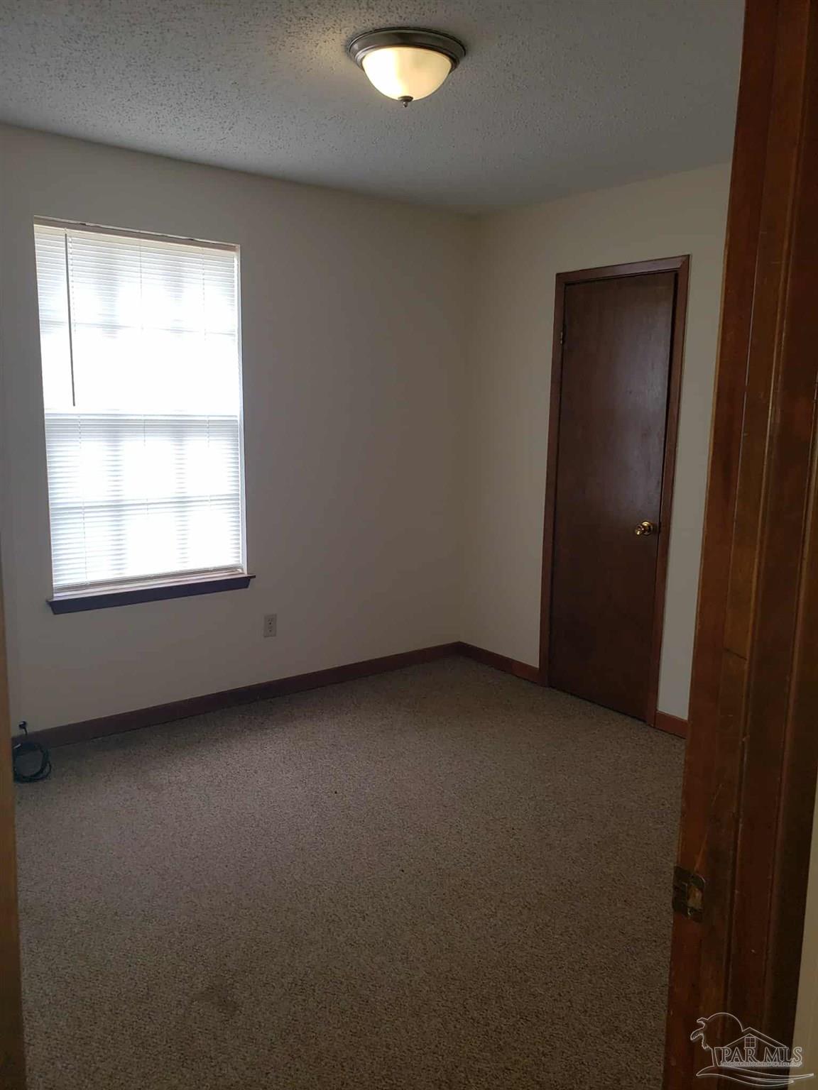 820 Calhoun Avenue, Unit A Pensacola, FL 32507 - Photo 6 of 9 an empty room with a window