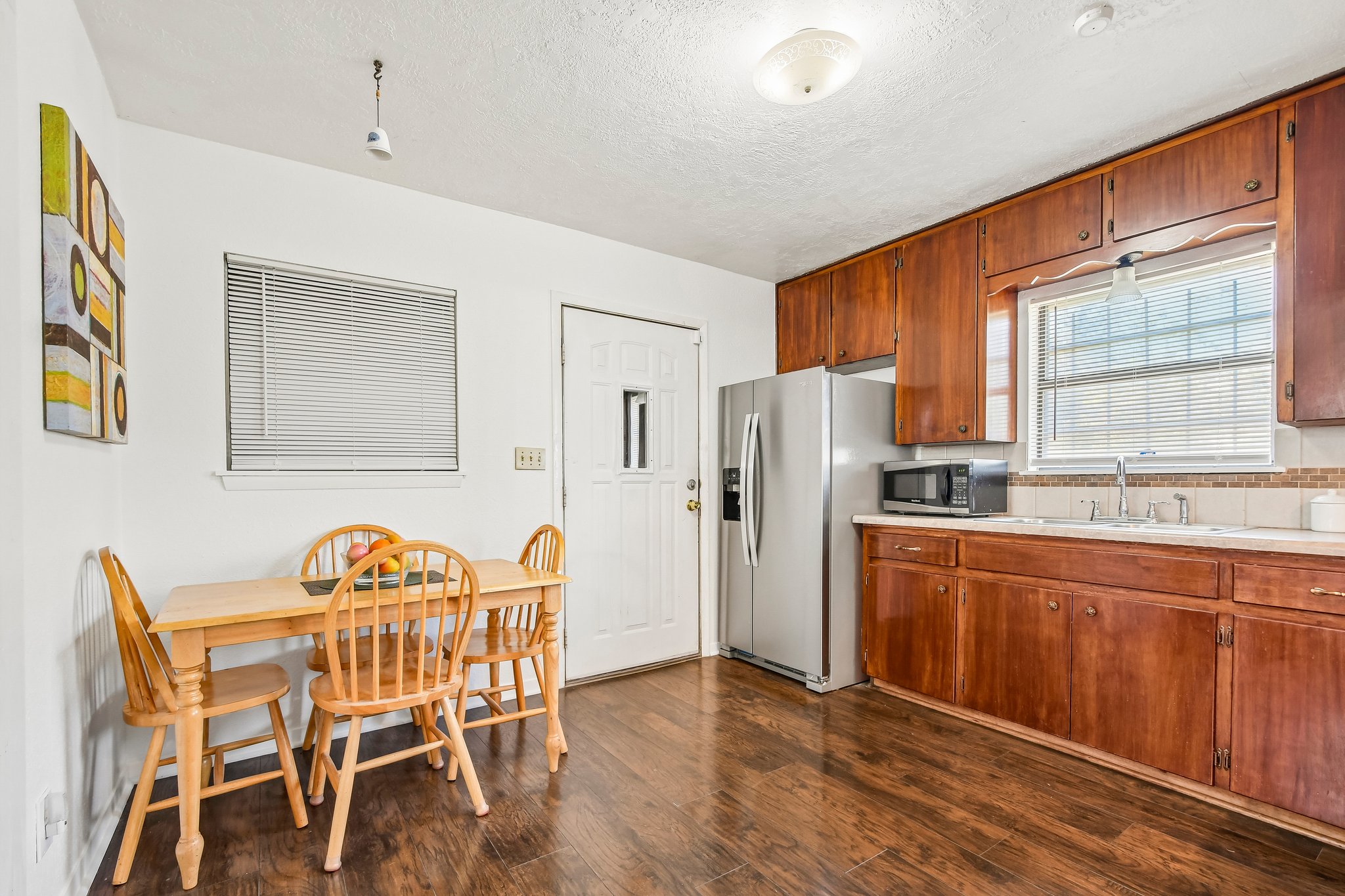 101 Brown Street Elgin, TX 78621 - Photo 11 of 32 a kitchen with stainless steel appliances a refrigerator a sink dishwasher with a dining table and chairs