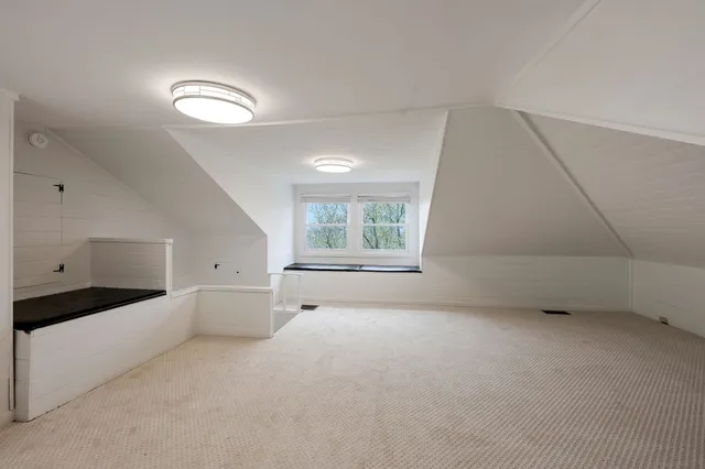 a large white room with a window and a kitchen