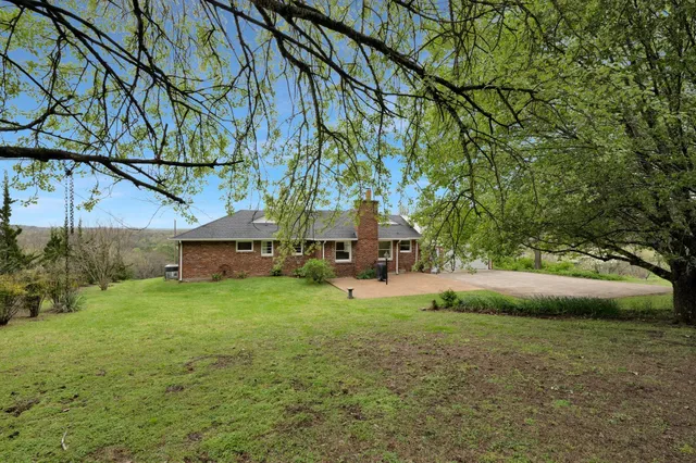 a view of backyard of house with green space