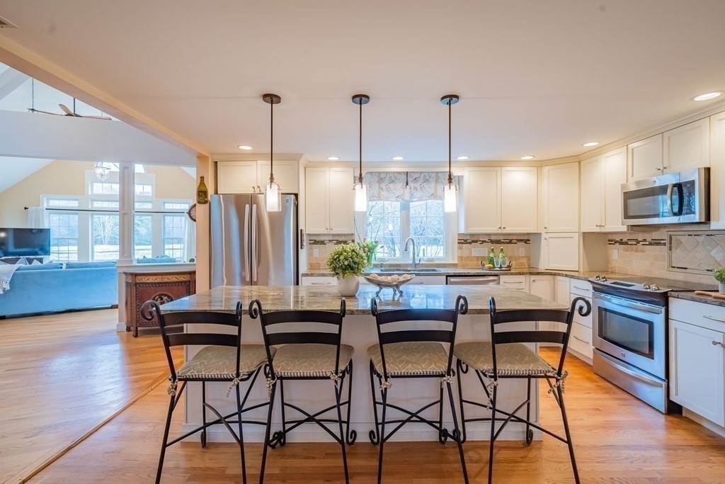 51 Robinson Road Lexington, MA 02420 - Photo 11 of 42 a kitchen with stainless steel appliances granite countertop table chairs and a stove