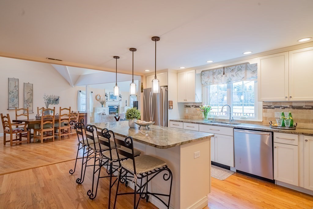 51 Robinson Road Lexington, MA 02420 - Photo 12 of 42 a dining hall with stainless steel appliances granite countertop a kitchen island a stove a table and chairs