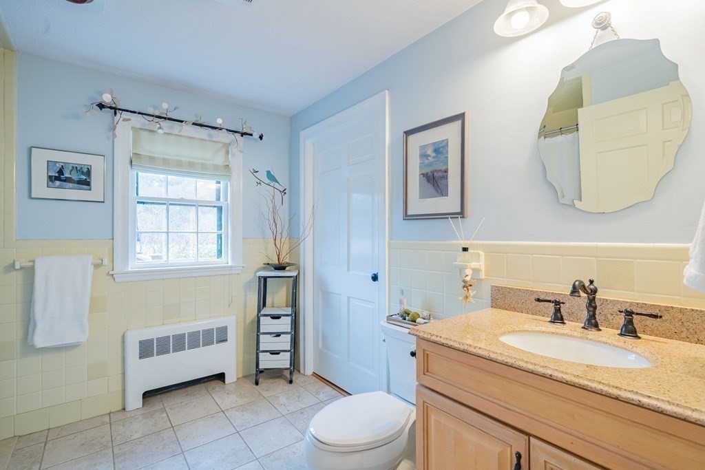 51 Robinson Road Lexington, MA 02420 - Photo 24 of 42 a bathroom with a granite countertop sink mirror vanity and toilet