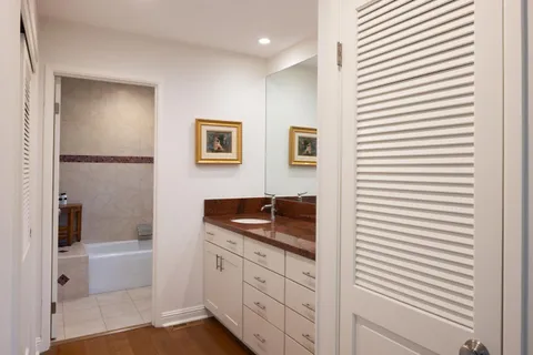 a bathroom with a granite countertop sink and a shower