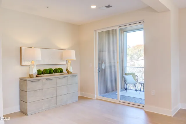 a view of a dining room and livingroom with furniture wooden floor a rug and a chandelier