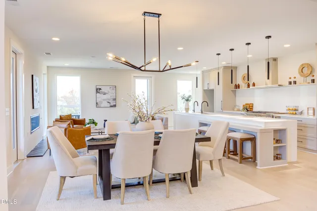 a kitchen with kitchen island a stove a table and chairs