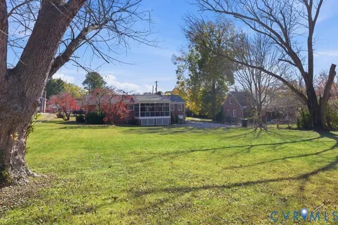 a view of a tennis ground with large trees