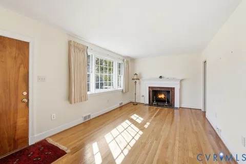 a view of an empty room with a window and fireplace