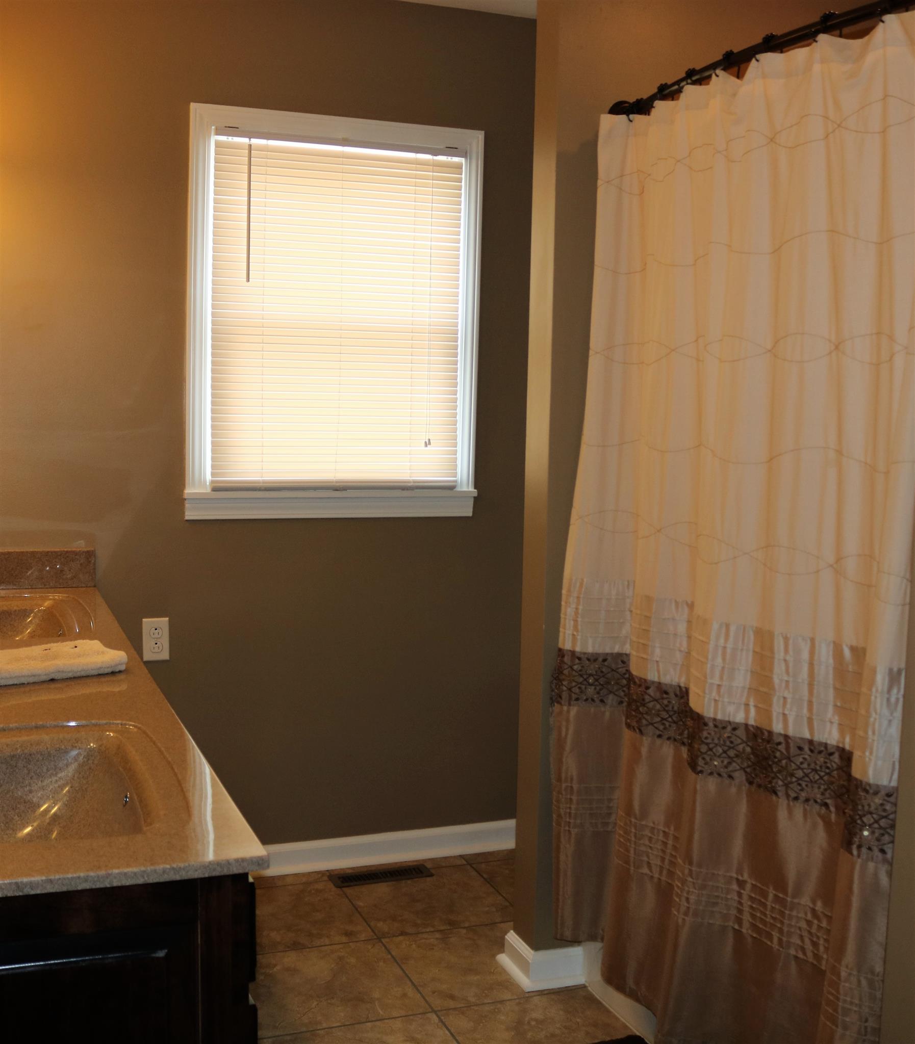 5937 Lakeview Road Springfield, TN 37172 - Photo 13 of 26 a bathroom with a window and a shower curtain