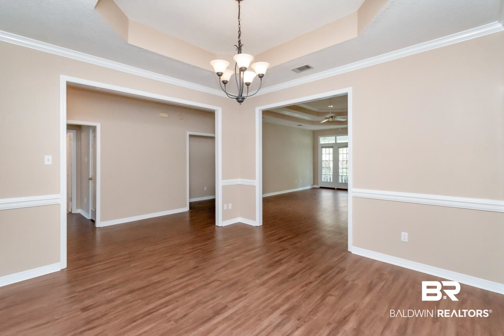 6117 Lennox Place Mobile, AL 36693 - Photo 7 of 39 Spare room featuring an inviting chandelier, a raised ceiling, baseboards, wood finished floors, and visible vents