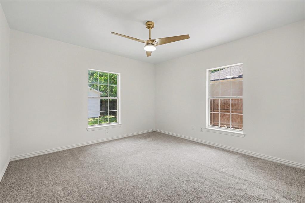 307 Dixon Street Terrell, TX 75160 - Photo 23 of 32 Room featuring a textured carpet, white walls, and a ceiling fan with integrated lighting