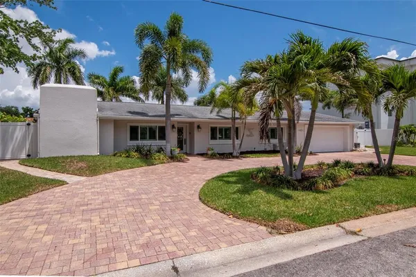 a front view of a house with a yard and potted plants