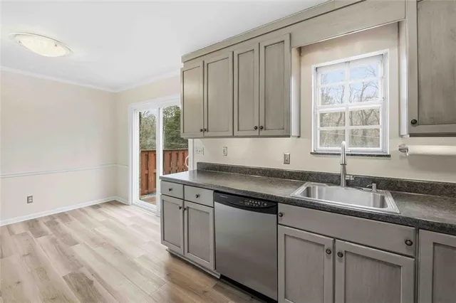 a kitchen with granite countertop a sink cabinets and wooden floor