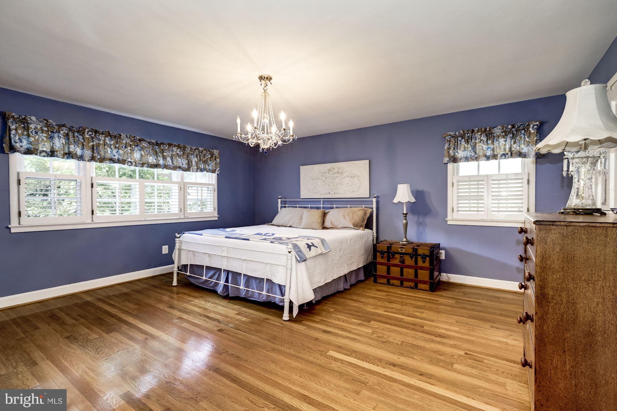 4767 Berkeley Terrace Northwest Washington, DC 20007 - Photo 17 of 30 a spacious bedroom with a bed chandelier and window