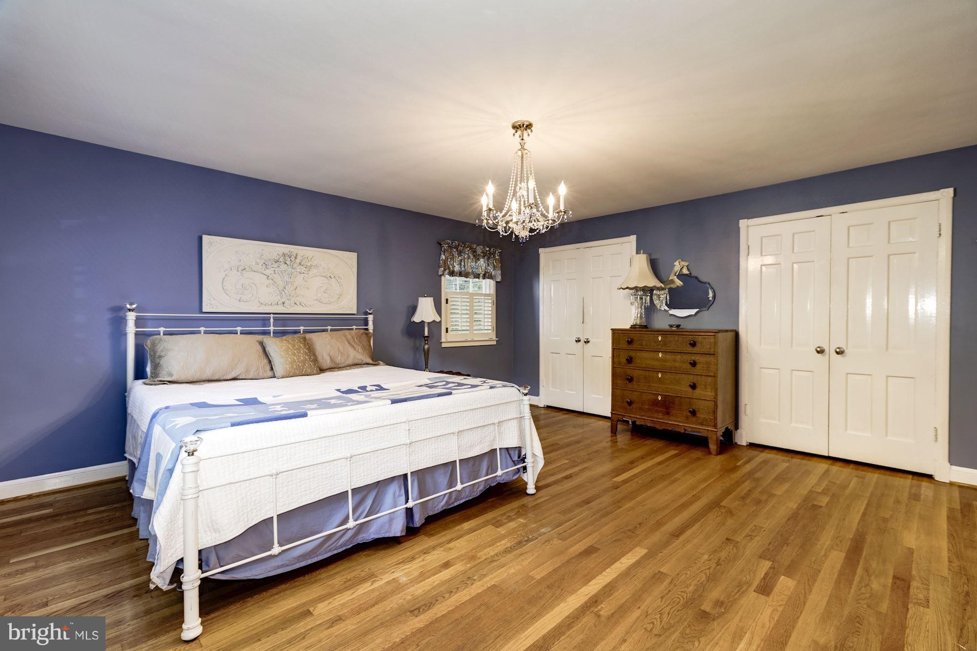 4767 Berkeley Terrace Northwest Washington, DC 20007 - Photo 18 of 30 a spacious bedroom with a bed a dresser and chandelier