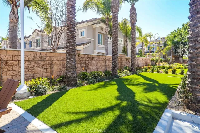 a view of a house with a big yard plants and palm trees
