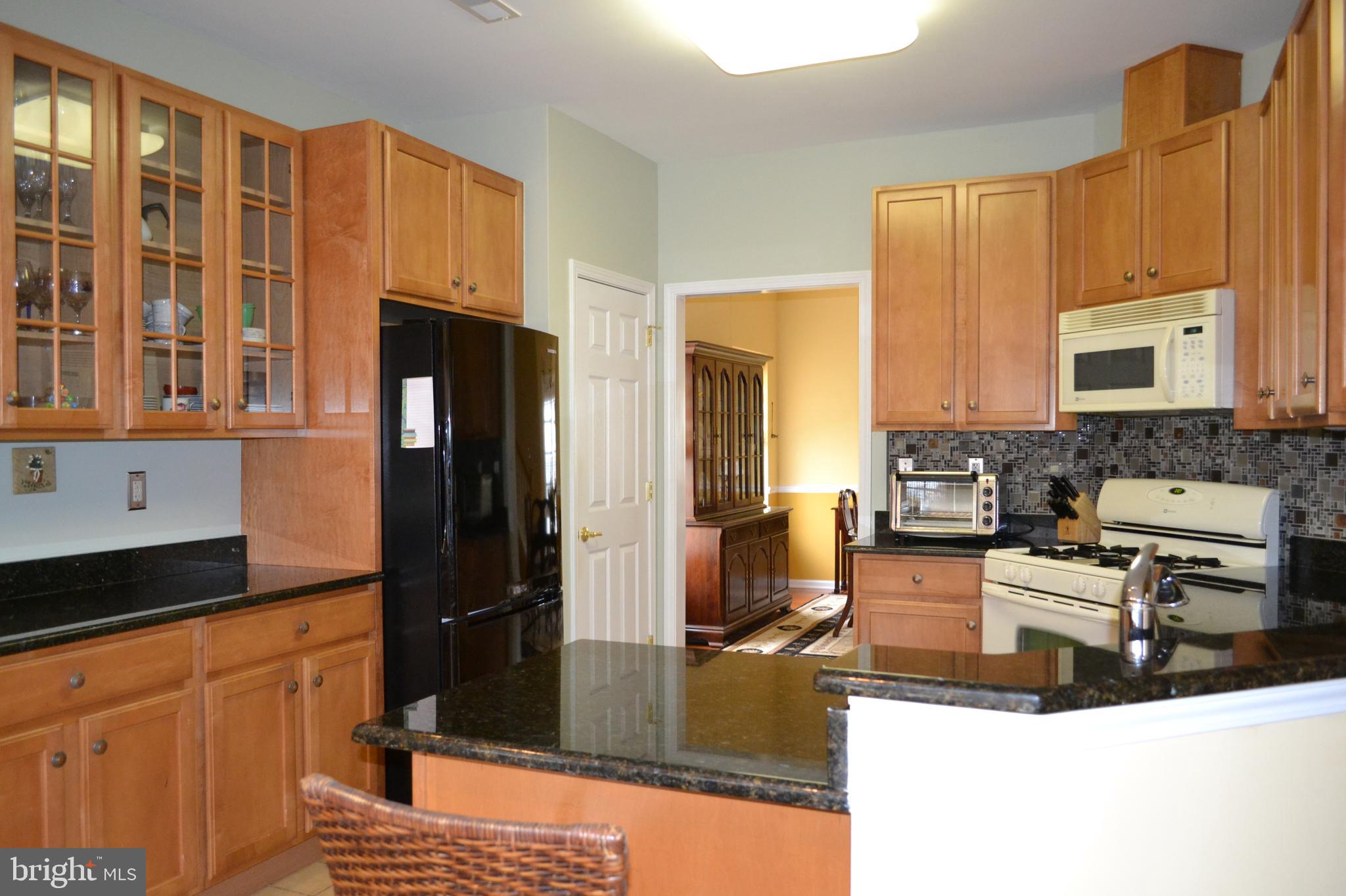 40 Brentwood Road Upper Chichester, PA 19061 - Photo 24 of 95 a kitchen with stainless steel appliances granite countertop a refrigerator a stove and a sink with wooden cabinets