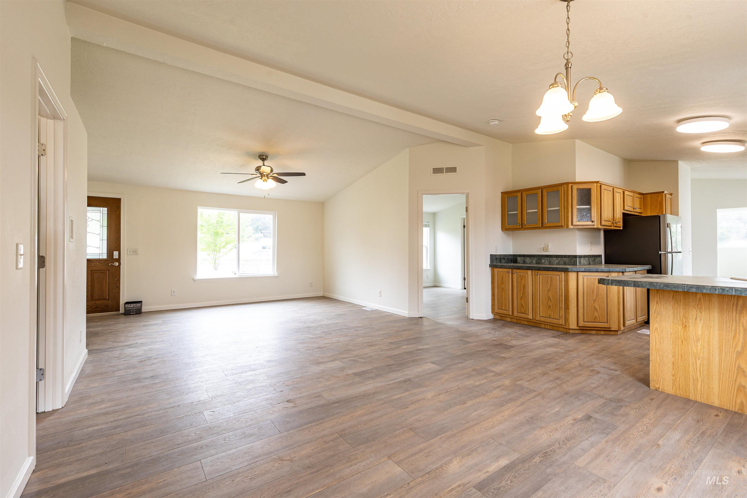 17028 Lower Pleasant Ridge Road Caldwell, ID 83607 - Photo 6 of 21 Open-concept living area with wood-finish flooring, a vaulted ceiling, and an integrated kitchen