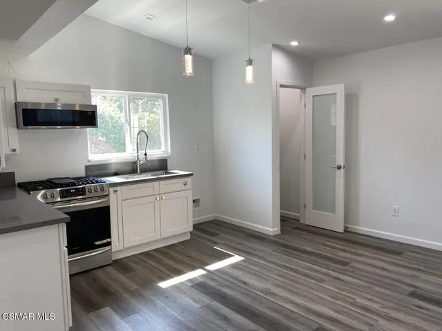 a kitchen with granite countertop a stove and a sink