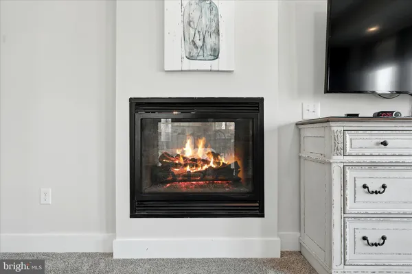 a dining room with stainless steel appliances kitchen island granite countertop a dining table chairs and a refrigerator