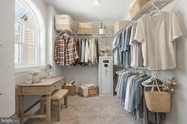 a view of walk in closet with clothes and shoes