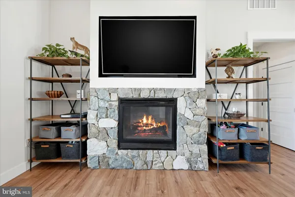 a kitchen with stainless steel appliances granite countertop a refrigerator a stove top oven a sink dishwasher a dining table and chairs with wooden floor