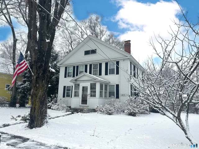 a front view of a house with a yard covered in snow
