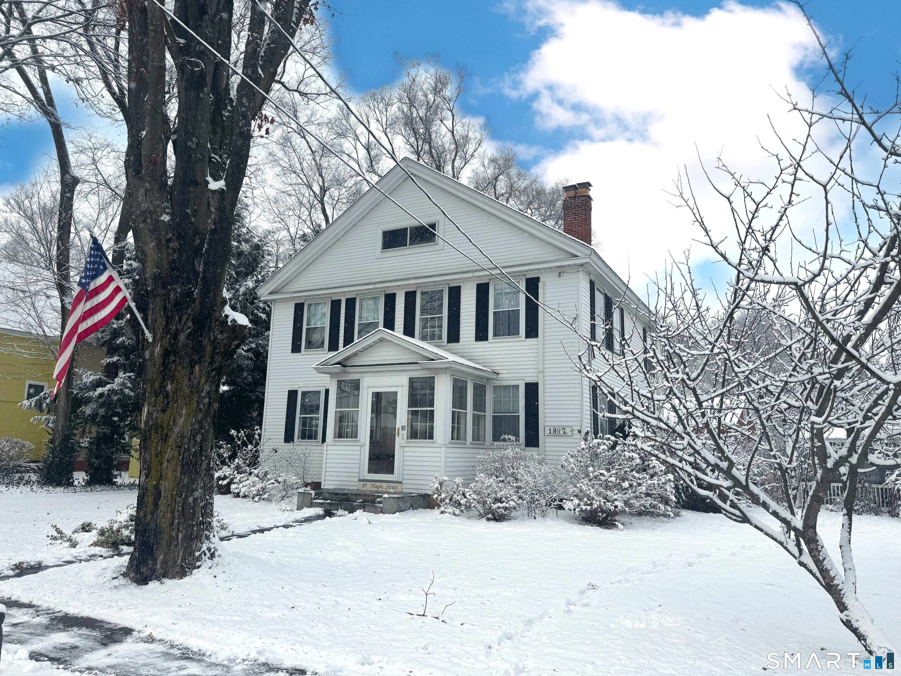 89 Maple Street Ellington, CT 06029 - Photo 2 of 40 a front view of a house with a yard covered in snow