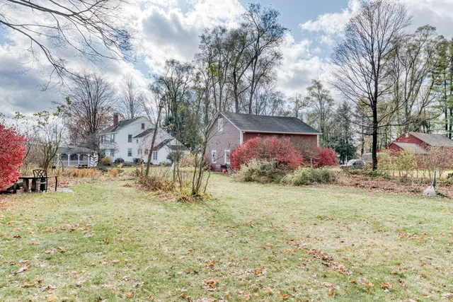 a backyard of a house with lots of green space and fountain