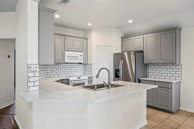 a kitchen with kitchen island a sink stove and refrigerator