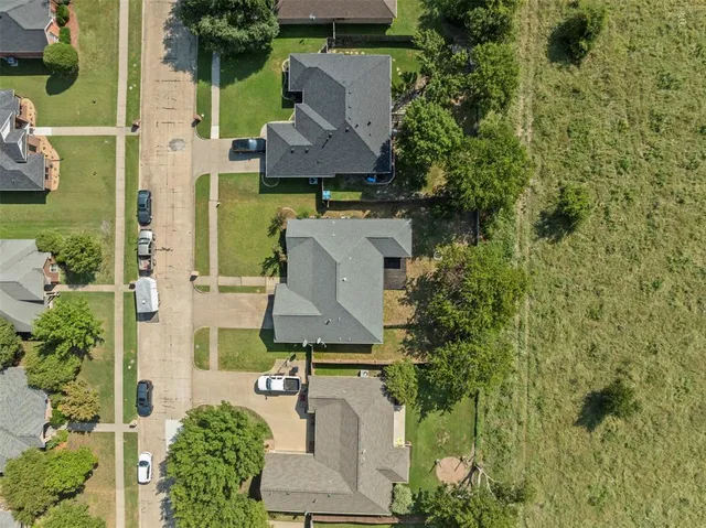 an aerial view of a house with a garden and trees