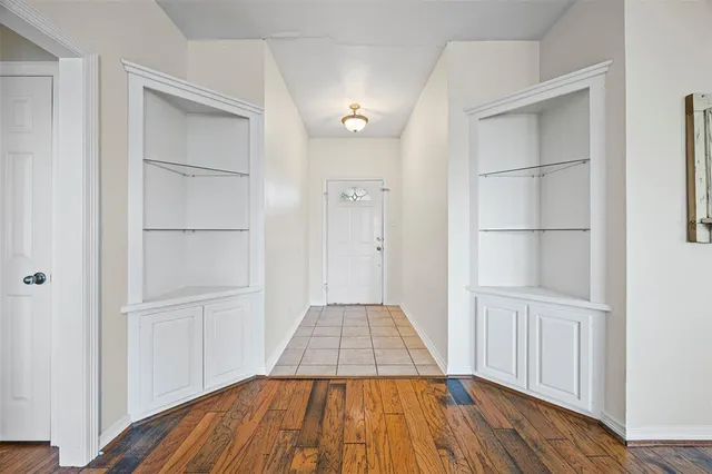 a view of a bedroom with wooden floor & closet