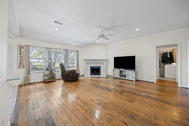 a view of a livingroom with furniture a flat screen tv and wooden floor