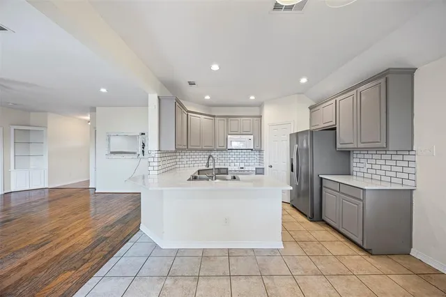 a kitchen with stainless steel appliances a refrigerator sink and cabinets