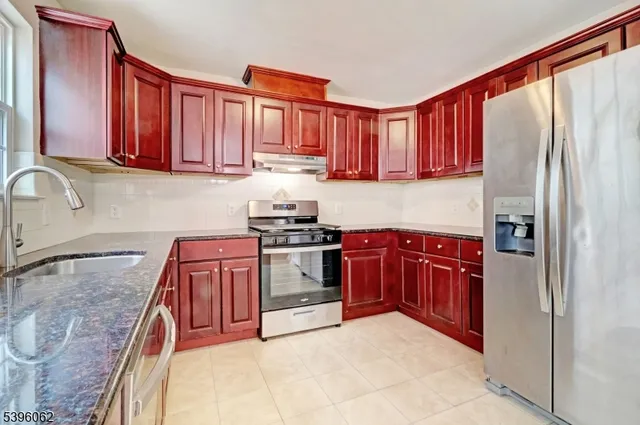 a kitchen with stainless steel appliances granite countertop a refrigerator and a stove top oven