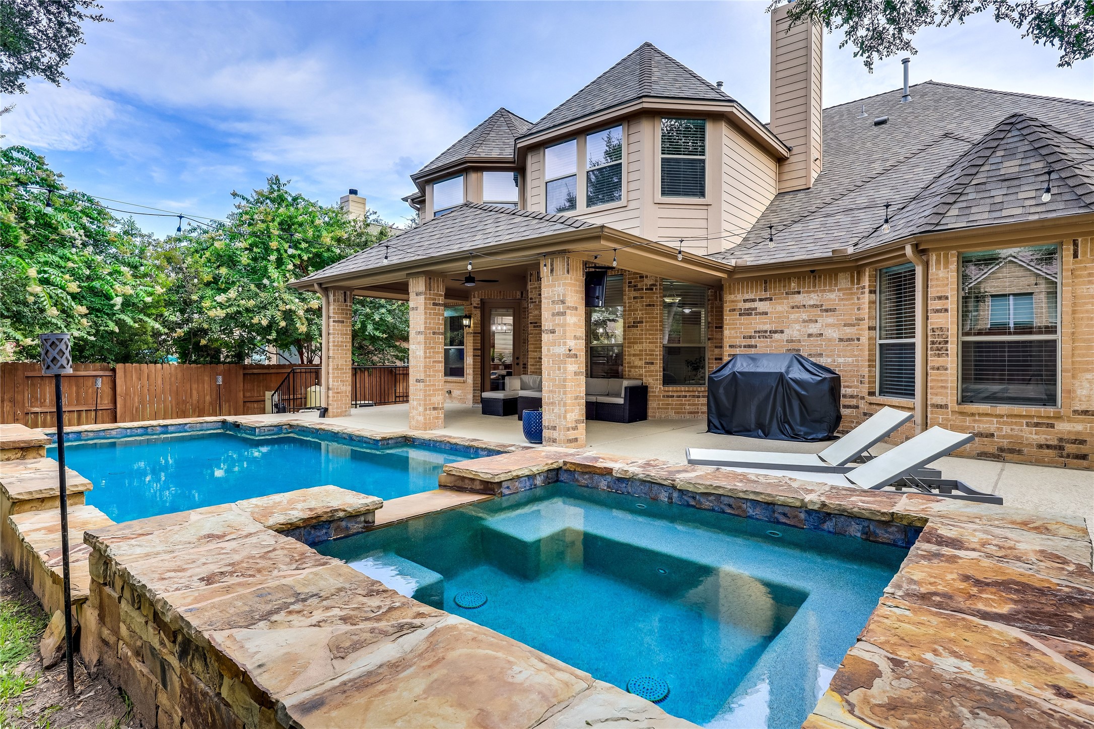 408 Ridgetop Bend Cedar Park, TX 78613 - Photo 38 of 40 An inviting backyard oasis offers a sparkling pool and spa, complementing the home's brick exterior and covered patio.