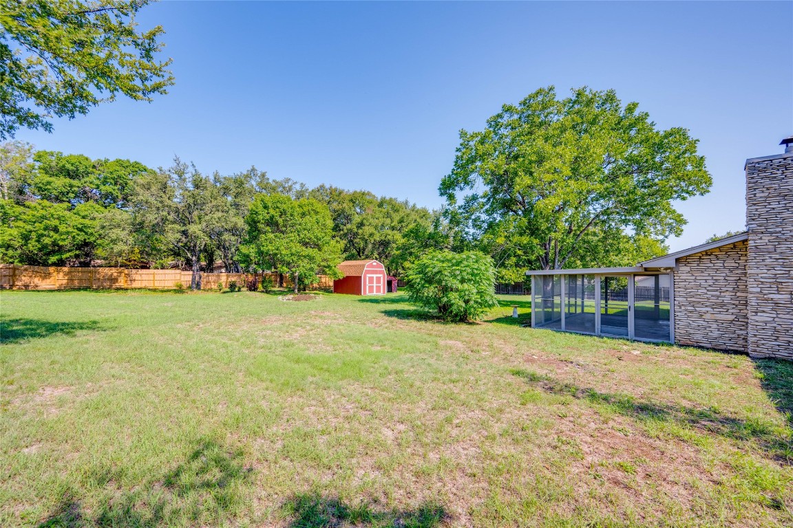 a view of a house with backyard and trees