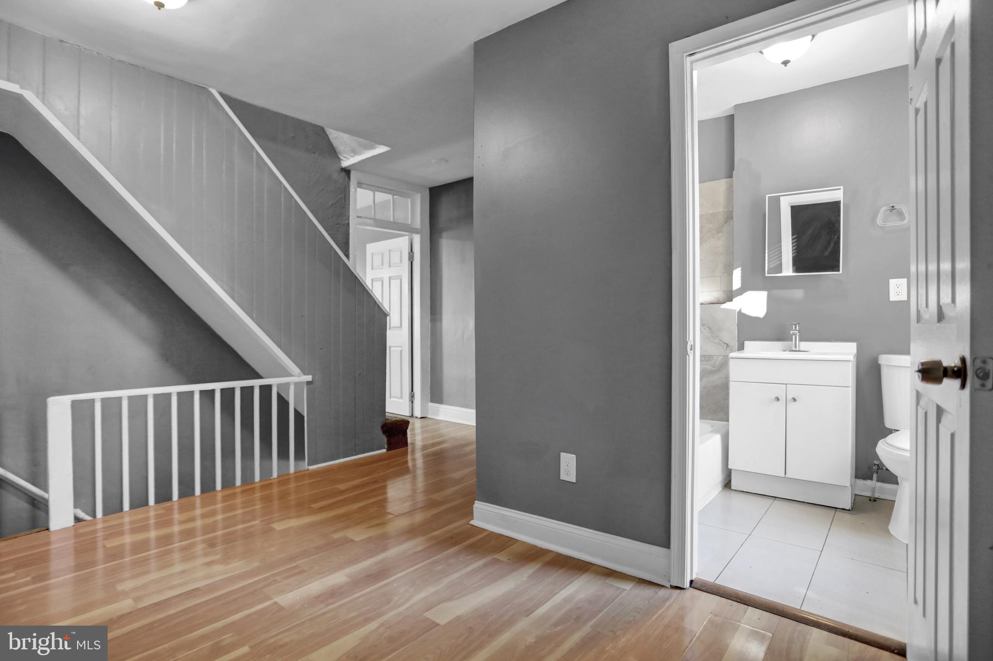 957 Bennett Place Baltimore, MD 21223 - Photo 12 of 30 a view of a hallway with bathroom and wooden floor