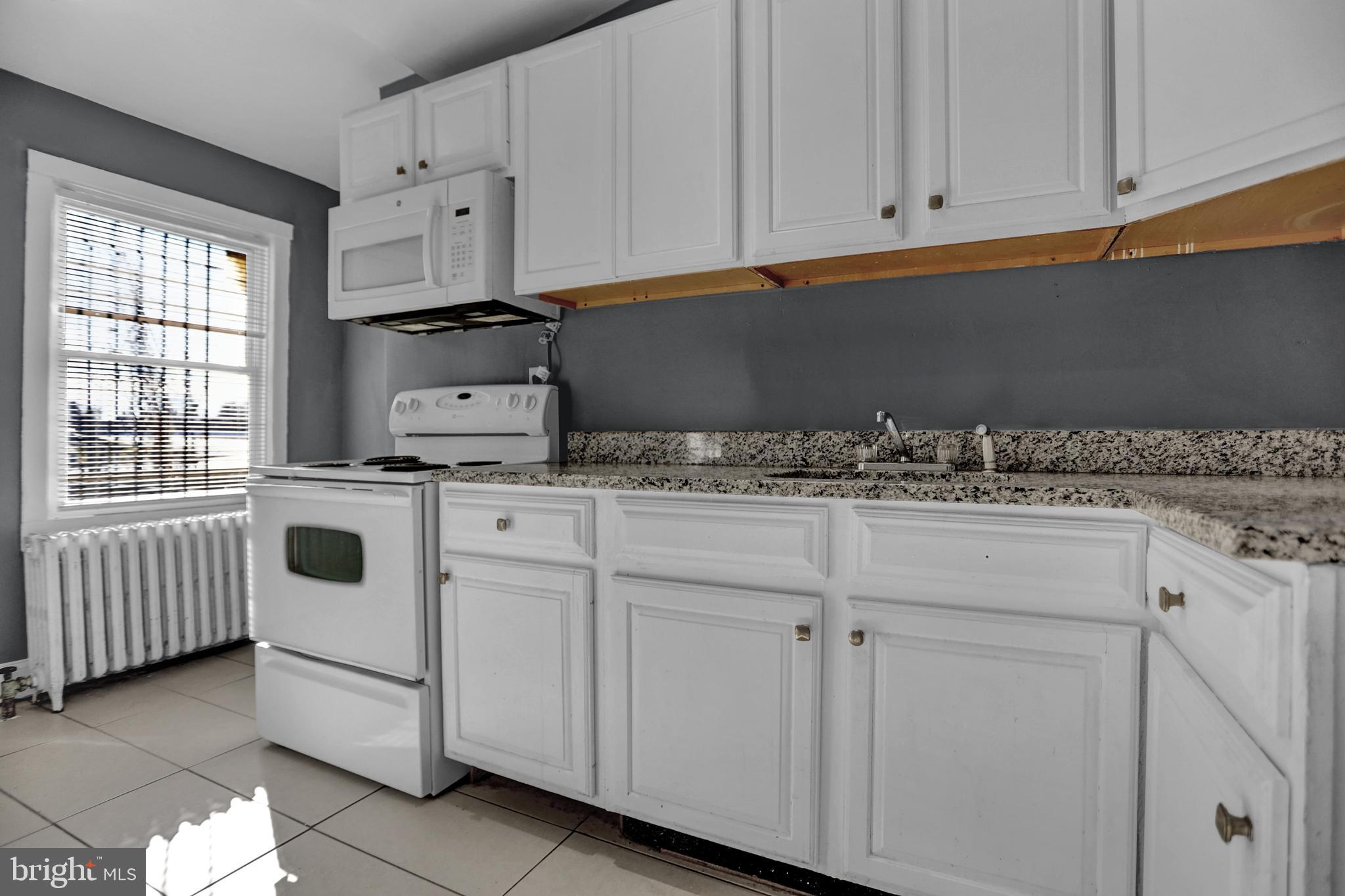 957 Bennett Place Baltimore, MD 21223 - Photo 4 of 30 a kitchen with white cabinets and white appliances