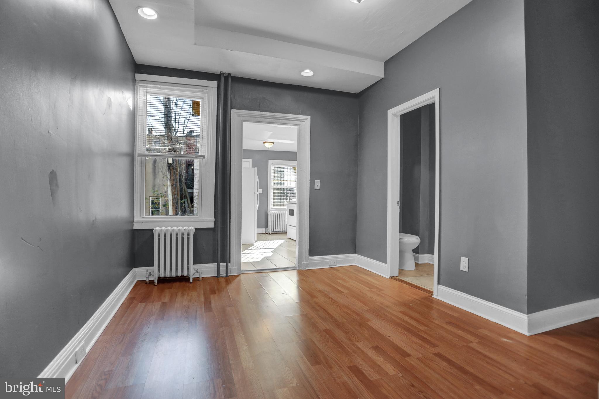 957 Bennett Place Baltimore, MD 21223 - Photo 9 of 30 wooden floor in an empty room with a window